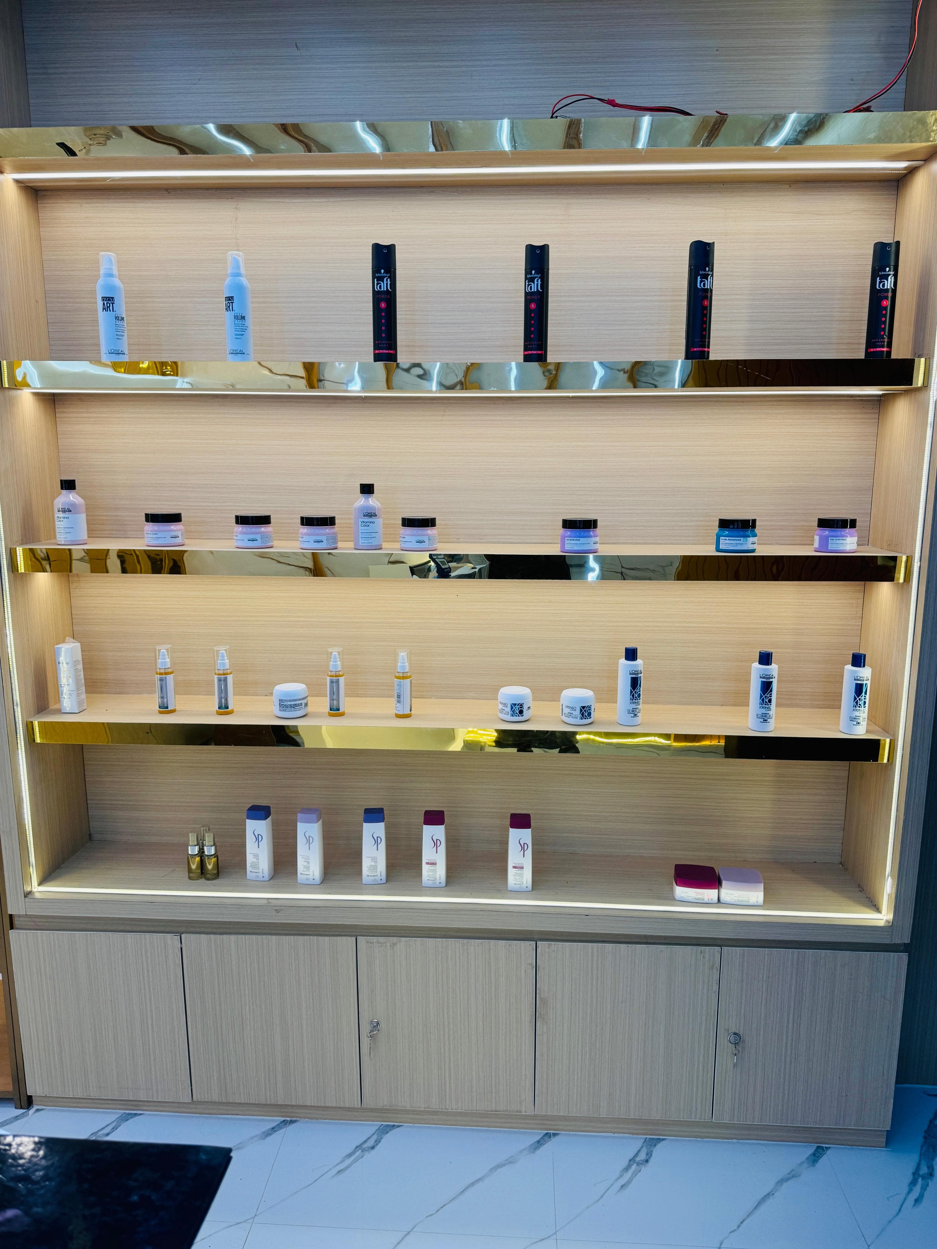Sainikpuri salon: backlit product wall with L'Oreal and Wella shelves